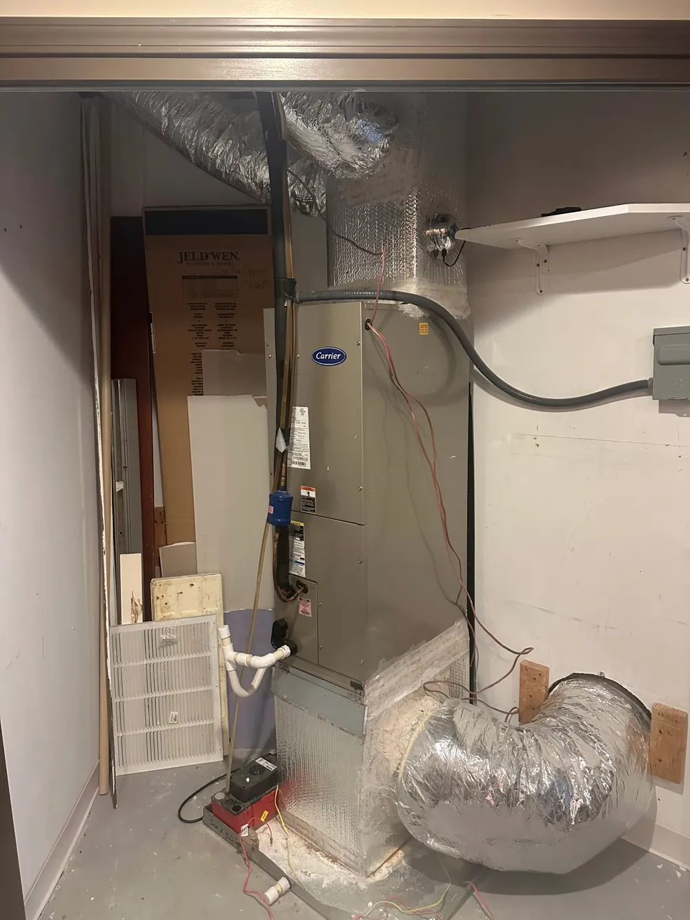 Old Carrier air handler in a closet before replacement