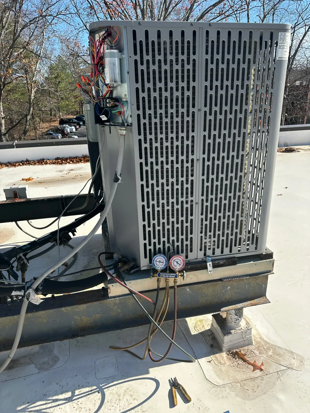 Rooftop air conditioner condenser connected to refrigerant gauges during service